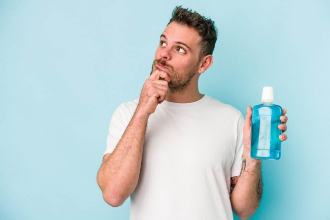 hombre con enjuague bucal