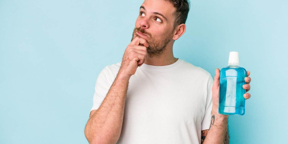 hombre con enjuague bucal